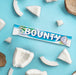 Bounty, la chocolatina de coco cubierta de chocolate con leche, pack de 24 barritas de 57g. Un snack exótico y delicioso ideal para disfrutar en cualquier momento y lugar. Bounty - detalle