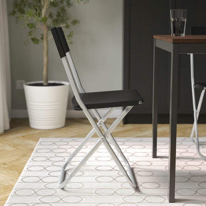 Ikea GUNDE Silla Plegable, Negro. La solución perfecta y económica para tener asientos extra. Ligera, resistente y fácil de guardar, es ideal para visitas, eventos y espacios pequeños. Ikea - lateral